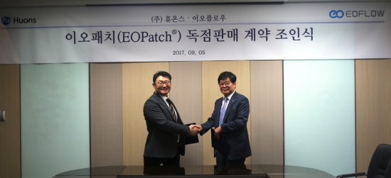 지난 2017년 김재진 이오플로우 대표(왼쪽)와 엄기안 휴온스 대표(오른쪽)가 이오패치 판매 계약을 체결하고 있는 모습