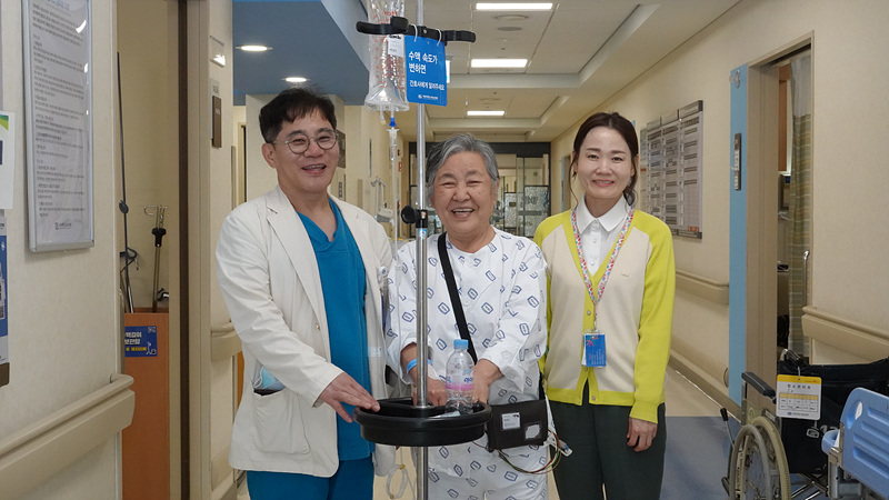 건강해진 환자와 함께 사진을 촬영하고 있는 장기육 교수(왼쪽).<br>